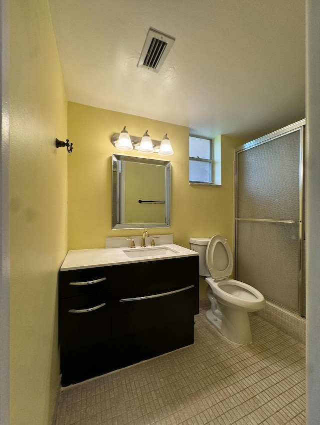 bathroom with vanity, toilet, and a shower with shower door