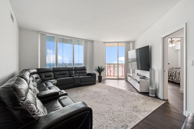 living room featuring dark wood-type flooring and ceiling fan