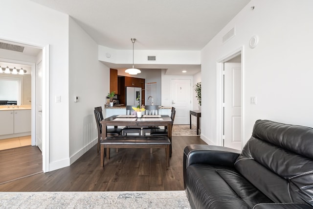 dining room with sink and dark hardwood / wood-style floors