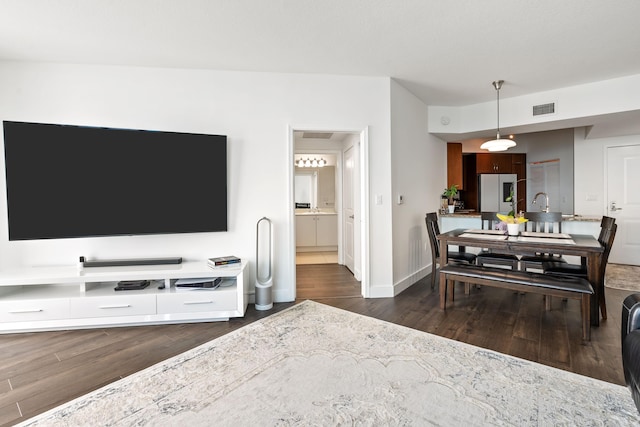 living room with sink and dark wood-type flooring