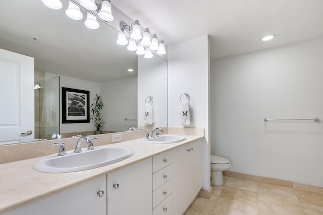 bathroom featuring tile patterned floors, double vanity, a shower with door, and toilet