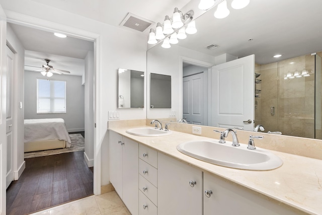 bathroom with dual vanity, a shower with shower door, wood-type flooring, and ceiling fan