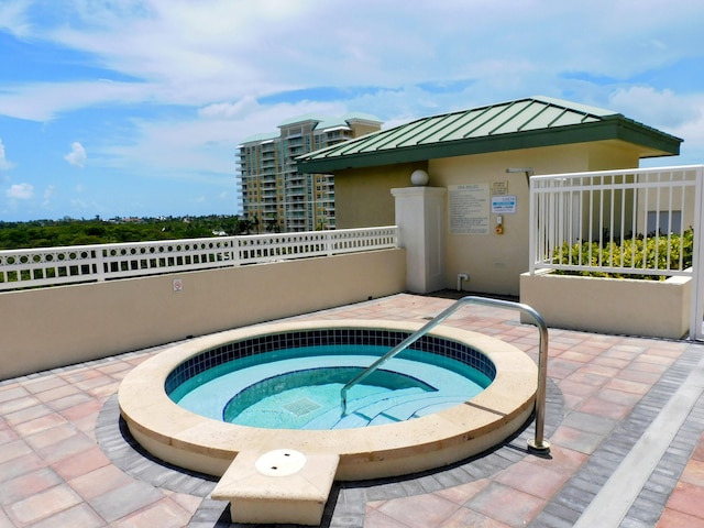 view of pool with a hot tub