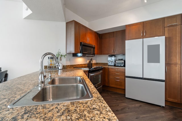 kitchen featuring white fridge, stainless steel range with electric stovetop, dark hardwood / wood-style flooring, light stone countertops, and sink