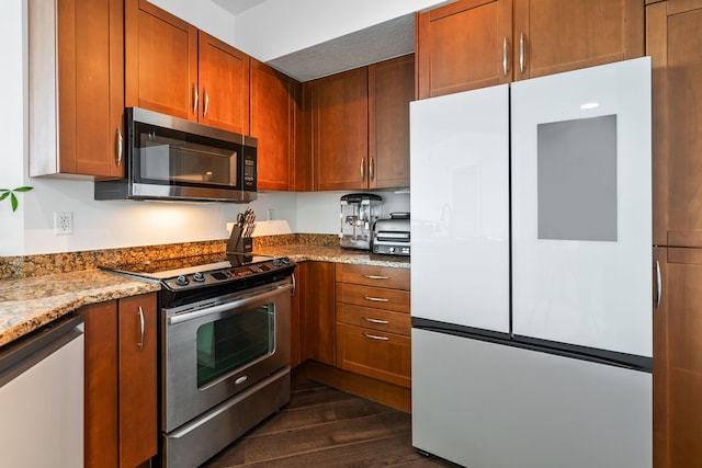 kitchen with dark hardwood / wood-style floors, stainless steel appliances, and stone countertops