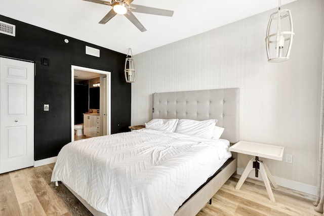 bedroom featuring ceiling fan, connected bathroom, and hardwood / wood-style flooring