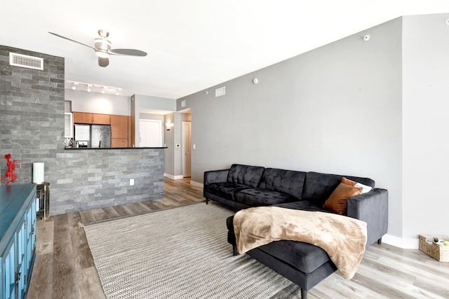 living room featuring ceiling fan and light hardwood / wood-style floors