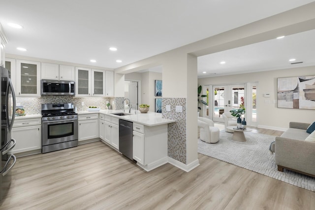 kitchen featuring light wood-type flooring, sink, appliances with stainless steel finishes, and white cabinetry