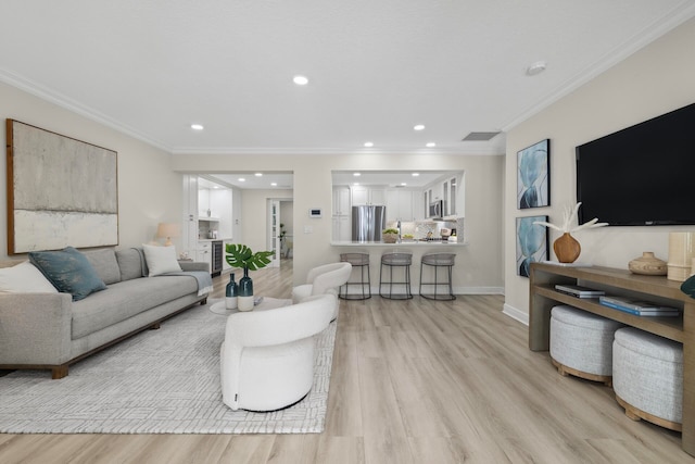 living room with ornamental molding and light hardwood / wood-style floors