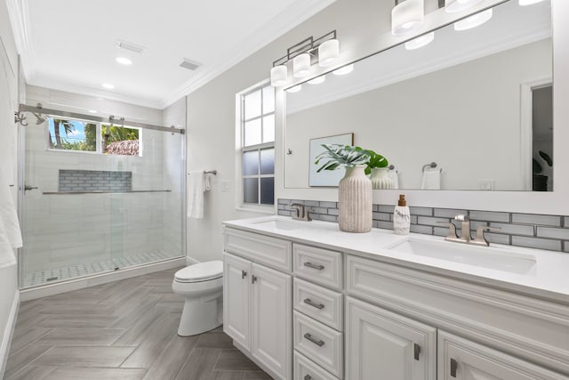 bathroom with ornamental molding, vanity, toilet, and a shower with door