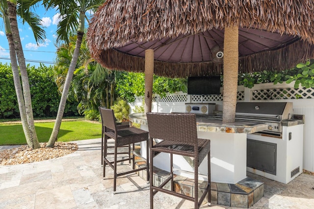 view of patio / terrace featuring area for grilling, a bar, and a gazebo