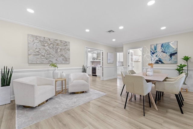 dining area with light wood-type flooring and ornamental molding