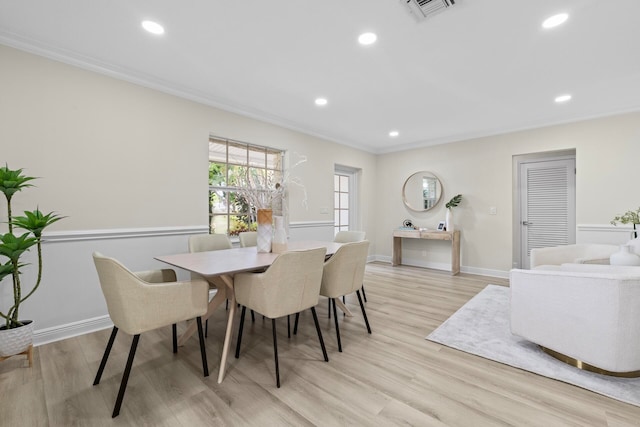 dining area featuring ornamental molding and light hardwood / wood-style floors