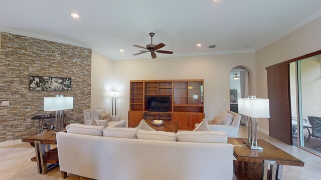 tiled living room with ceiling fan and crown molding