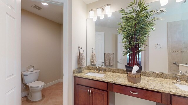 bathroom with toilet, tile patterned flooring, and vanity