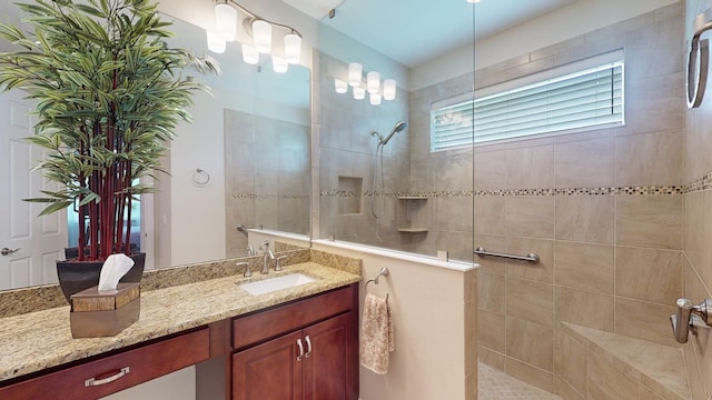 bathroom with vanity and a tile shower