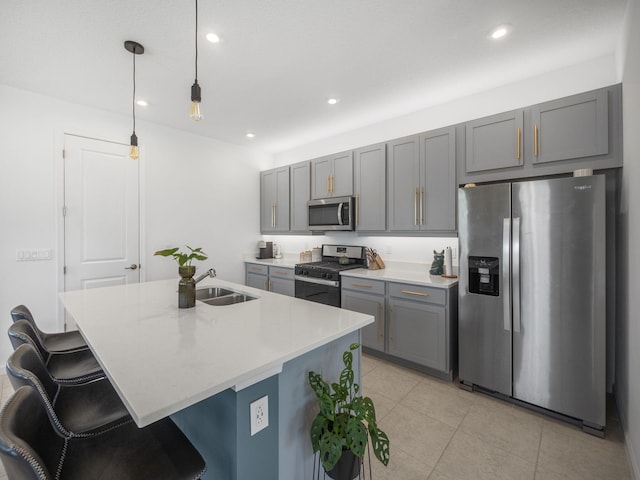 kitchen with sink, light tile patterned flooring, an island with sink, and stainless steel appliances