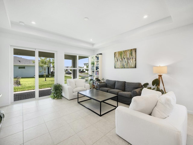 living room with light tile patterned flooring and a raised ceiling