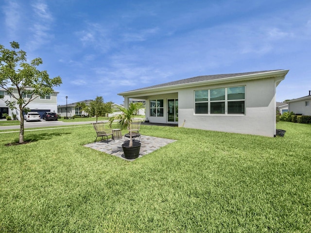 rear view of property with a patio and a lawn