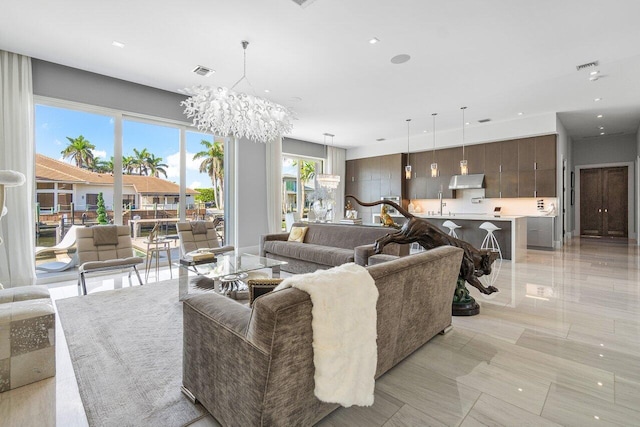 tiled living room with sink and an inviting chandelier