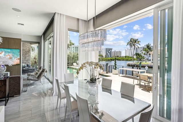 dining space featuring a chandelier and a water view