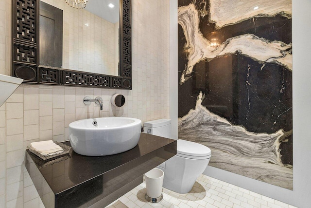 bathroom featuring tile patterned floors, sink, tile walls, and toilet