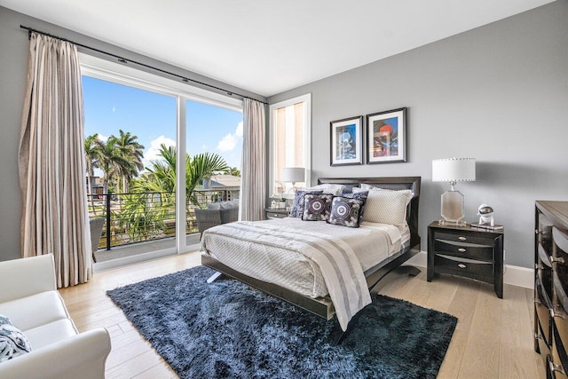 bedroom featuring light wood-type flooring and access to outside