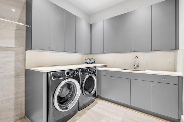 laundry room featuring cabinets, sink, and independent washer and dryer