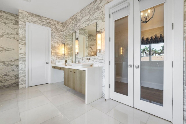 bathroom featuring vanity, tile walls, and a notable chandelier