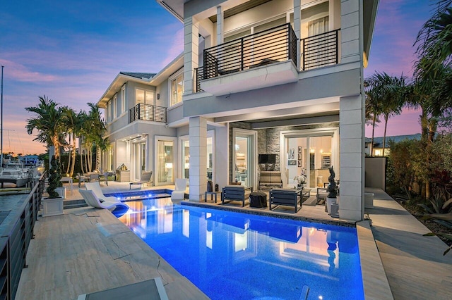 pool at dusk with a patio