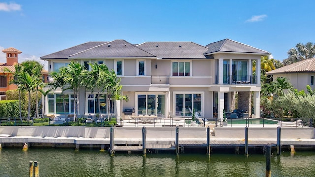 back of house featuring a balcony, a water view, and a patio area