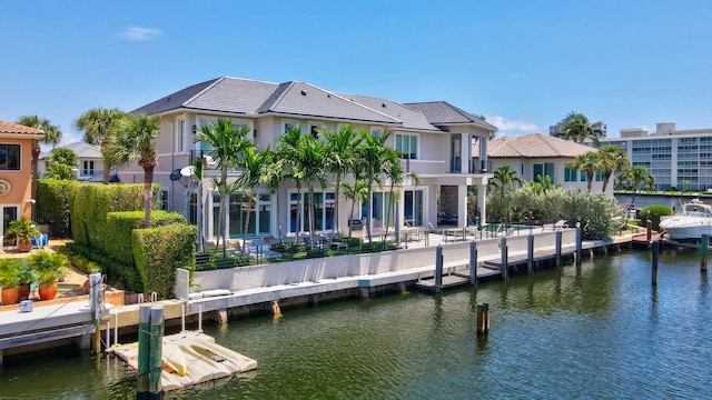 rear view of house featuring a water view and a balcony