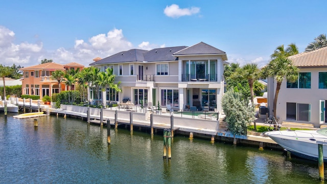 back of property featuring a balcony and a water view