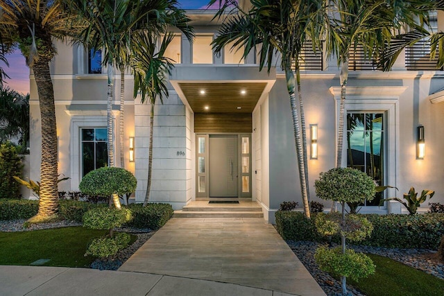 exterior entry at dusk featuring a balcony