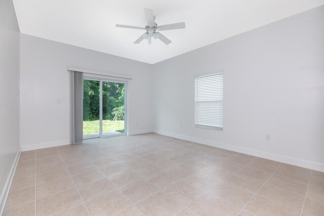 tiled spare room with ceiling fan