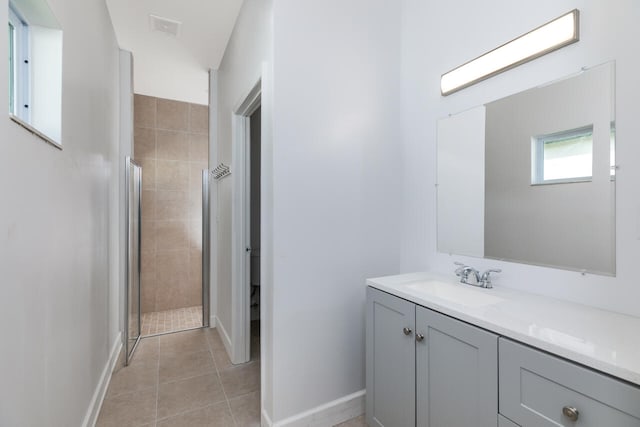 bathroom with tile patterned floors, a shower with door, and vanity