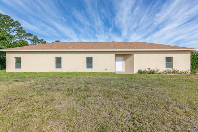 back of property with a lawn