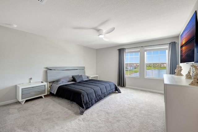 bedroom with light carpet, a ceiling fan, a textured ceiling, and baseboards