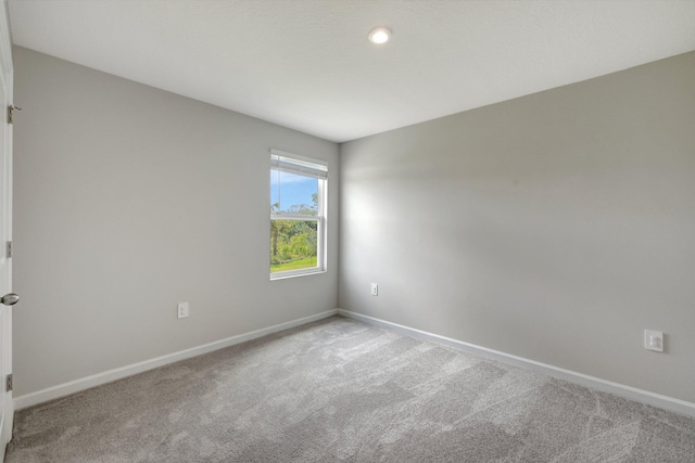 carpeted spare room with baseboards