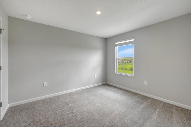 empty room featuring baseboards and carpet flooring