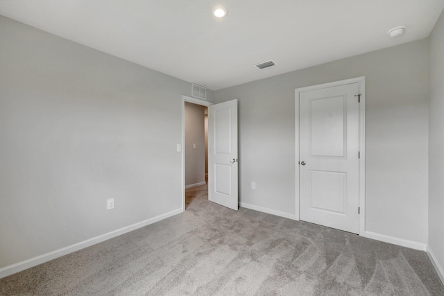 unfurnished bedroom featuring light carpet, baseboards, and visible vents