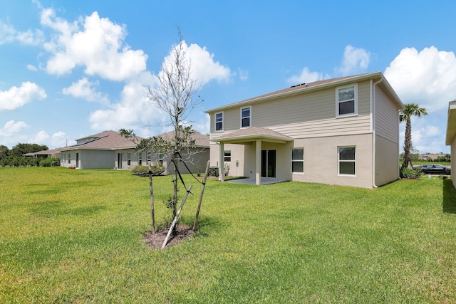 rear view of property featuring a patio and a yard