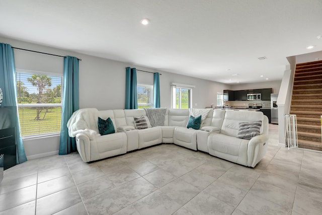 living area featuring recessed lighting, light tile patterned floors, stairs, and visible vents