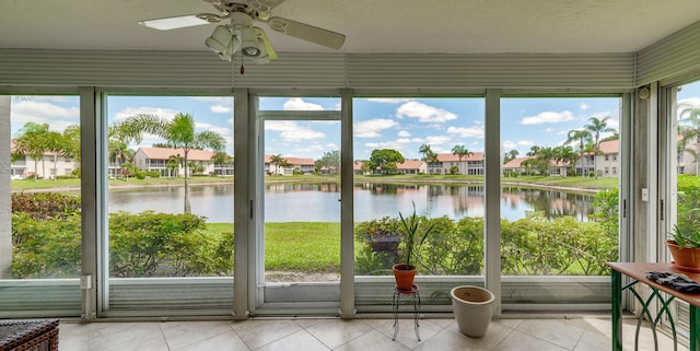 unfurnished sunroom featuring a water view and ceiling fan