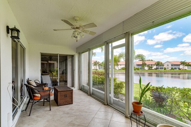 sunroom / solarium featuring a water view and ceiling fan