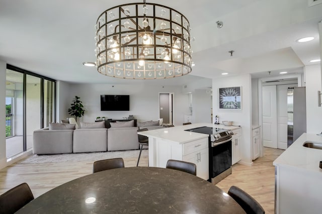 5279 Fountains Dr S Unit 602, Lake Worth, FL 33467 - interior space featuring white cabinets, light wood-type flooring, open floor plan, and stainless steel appliances