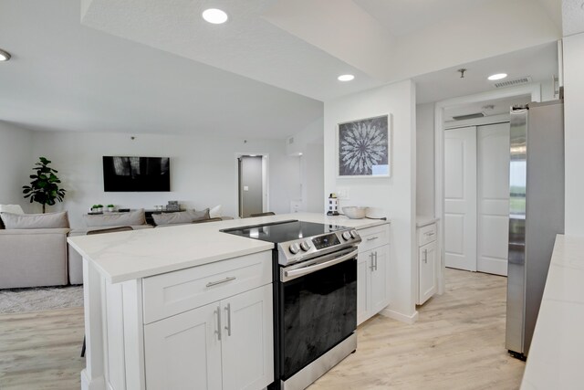 5279 Fountains Dr S Unit 602, Lake Worth, FL 33467 - kitchen with a peninsula, recessed lighting, white cabinetry, light wood-style floors, and appliances with stainless steel finishes
