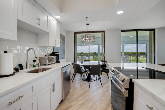 5279 Fountains Dr S Unit 602, Lake Worth, FL 33467 - kitchen featuring a sink, decorative backsplash, light wood-style floors, stainless steel appliances, and white cabinets