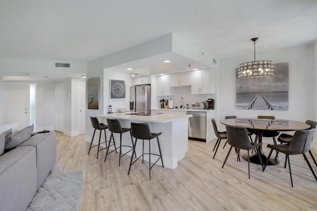 5279 Fountains Dr S Unit 602, Lake Worth, FL 33467 - kitchen with a kitchen breakfast bar, a sink, light wood-style floors, appliances with stainless steel finishes, and visible vents