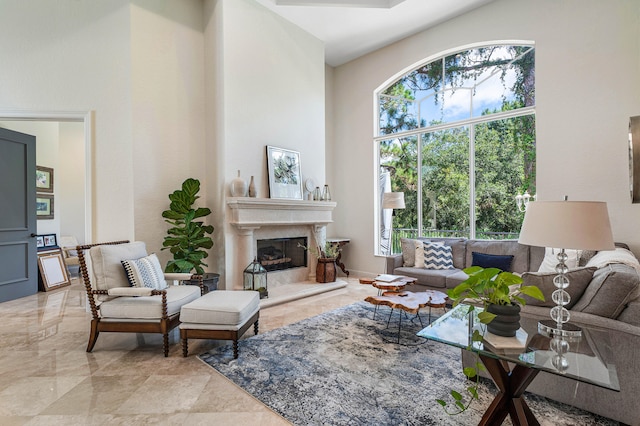 living room with a fireplace and a towering ceiling